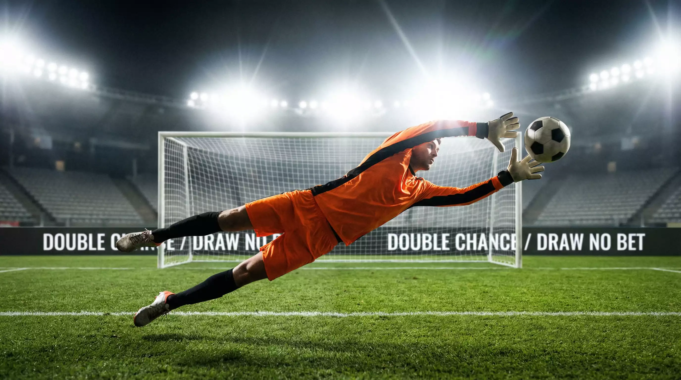 Gardien de football en position de plongeon devant ses buts sur une pelouse verte de stade éclairé
