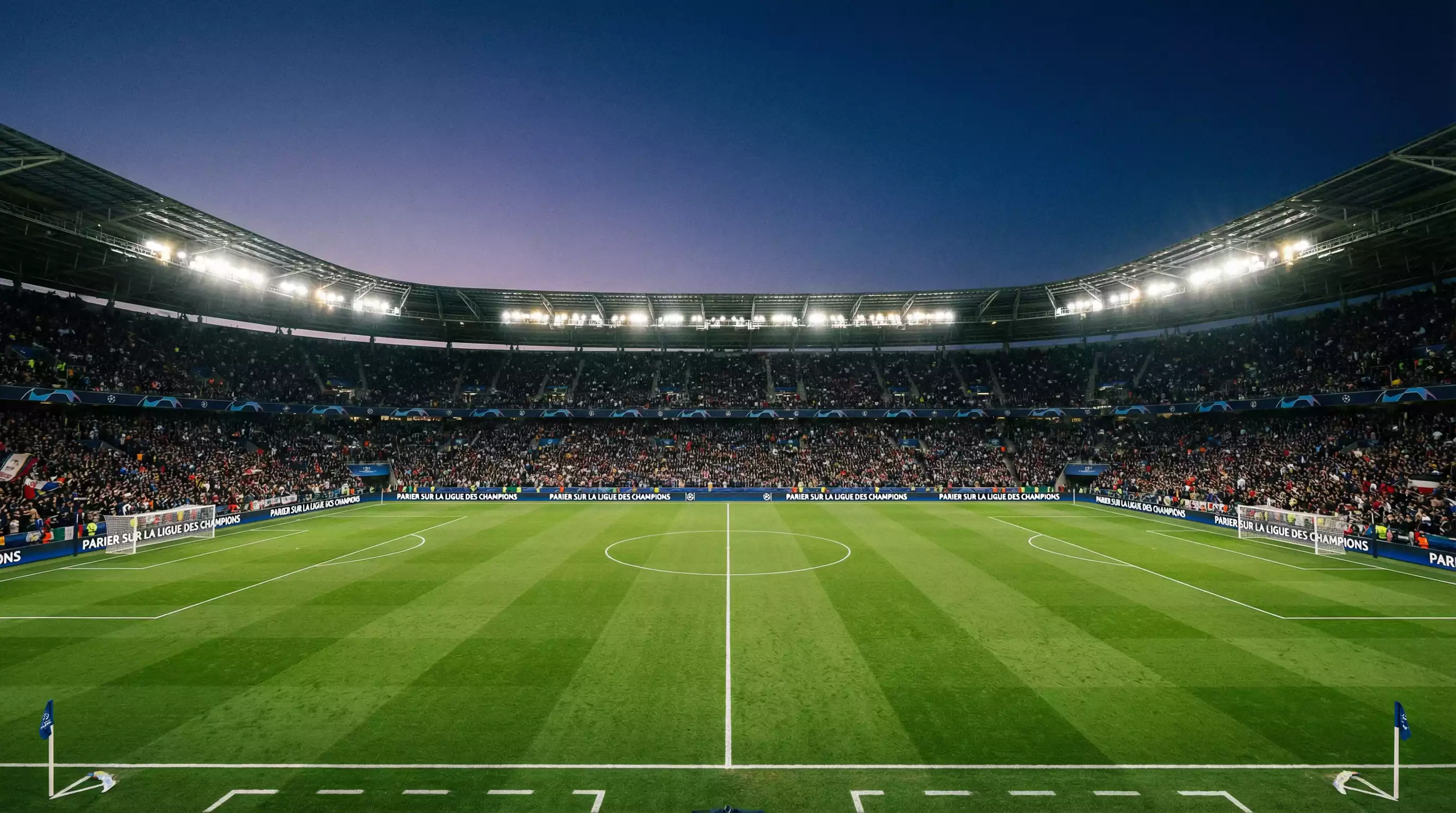 Stade de football européen illuminé en soirée avec le rond central et la pelouse impeccable avant un grand match